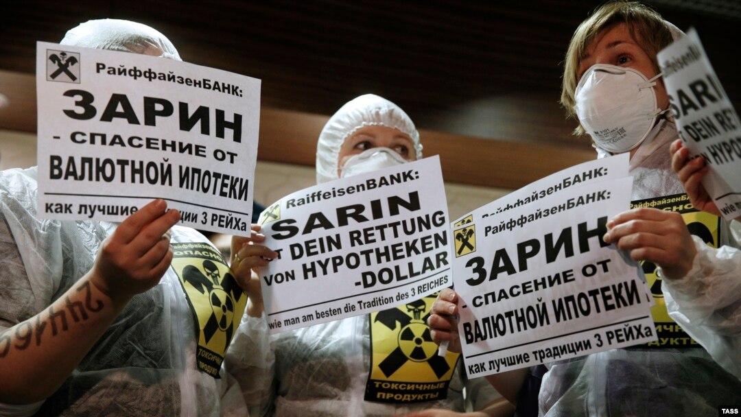 Protesters hold placards during a rally by foreign-currency mortgage holders at Raiffeisen Bank in Moscow in February last year. 