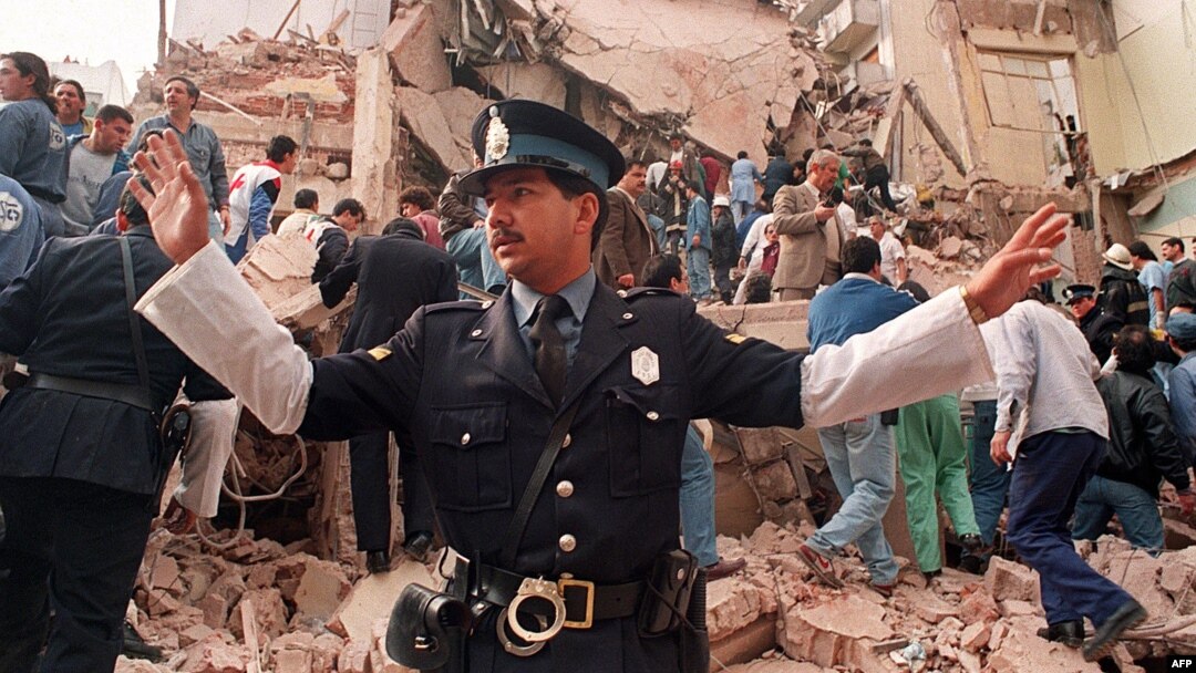 An Argentinian policeman prevents people from approaching the site where a powerful explosion destroyed the seven-story building housing the Jewish Mutual Association of Argentina in Buenos Aires in July 1994.