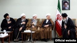 محمود هاشمی شاهرودی (چپ) و محمد یزدی (وسط)، دو عضو شورای نگهبان، در حال ابراز ارادت به آیت‌الله خامنه‌ای (راست).