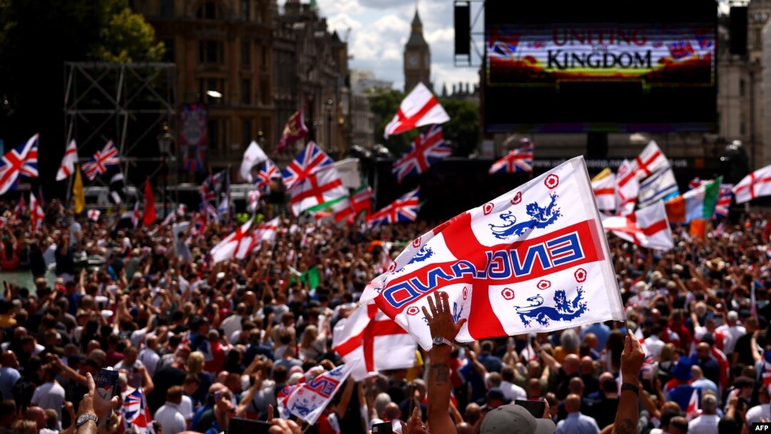 Pristalice britanskog ekstremno desničarskog aktiviste i osnivača i bivšeg lidera antiislamske engleske odbrambene lige (EDL), Stivena Jakslija-Lenona, takođe poznatog kao Tomi Robinson, prisustvuju mitingu na Trafalgar skveru u centru Londona 27. jula 2024.
