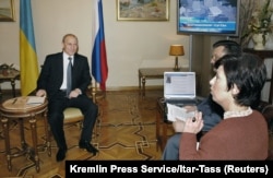 Владимир Путин слушает вопрос зрителя во время выступления на украинском телевидении в рамках визита в Киев. 26 октября 2004 года