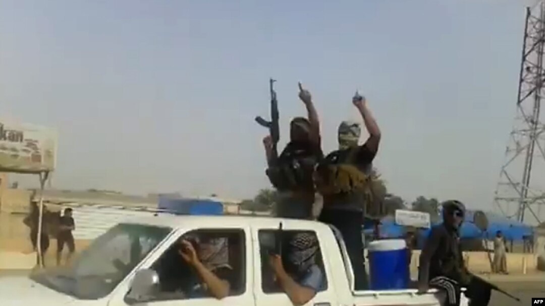 A screen grab taken from a video uploaded to YouTube on June 17 allegedly shows militants ISIL parading with their weapons in the northern Iraqi city of Baiji. 