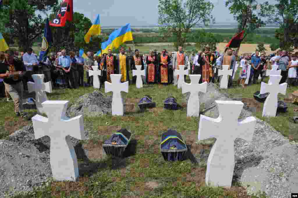 Священики проводять службу під час церемонії перепоховання 23-х солдатів 14-ї гренадерської дивізії Ваффен СС «Галичина», які загинули під час Другої світової війни в битві під Бродами (липень 1944 року). Село Червоне недалеко від Львова, 23 липня 2017 року