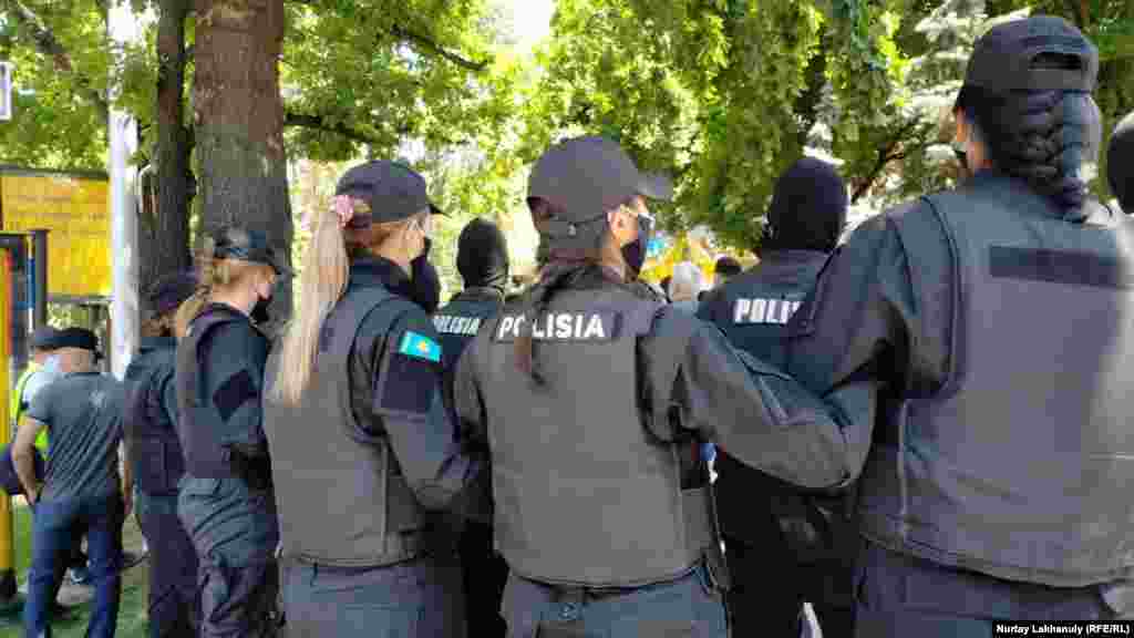 Полицейлер билікке талап айтқан наразыларды қоршап тұр. Полиция алаңға өткізбей қойған азаматтардың кейбірі сол жерде-ақ билікке талабын айта бастады. Олар Алматы әуежайының сатылуына, жерді шетелдіктерге жалға беруге қарсы екенін, табиғи ресурсқа бай мемлекетте халықтың кедейлік тауқыметін тартып отырғанын айтты.