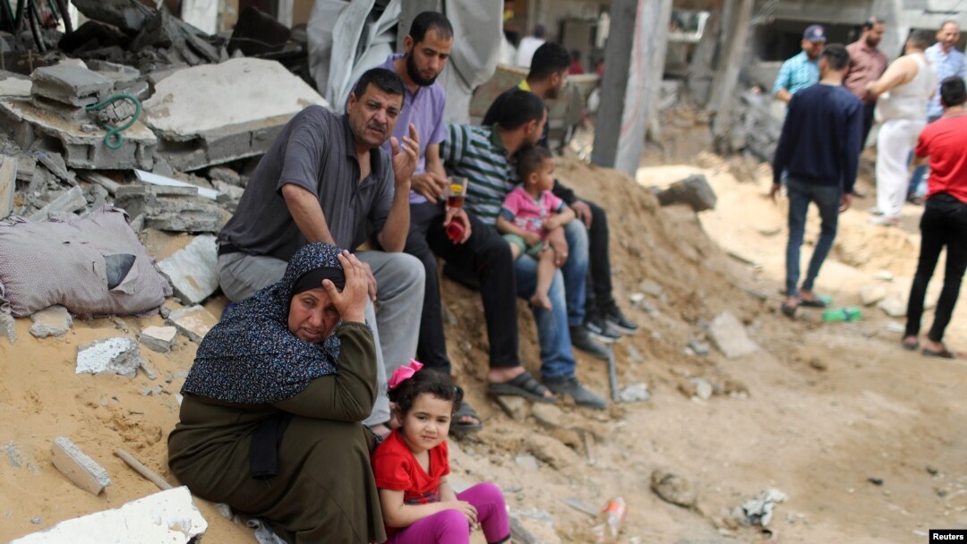 Palestinci pored srušenih kuća u Beit Hanounu u sjevernom pojasu Gaze, 21. maja 2021. 