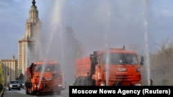 Vehicles spray disinfectant as they sanitize a road near the main building of the Lomonosov Moscow State University in Moscow on April 24.