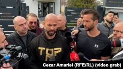 Andrew Tate (în centru) și fratele său, Tristan, în fața sediului Poliției Voluntari, unde s-au prezentat în 24 martie.