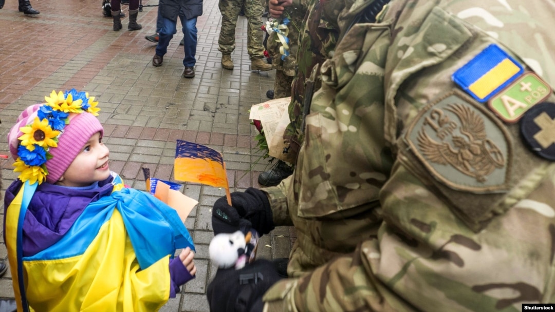 Ілюстраційне фото. Дівчинка дарує прапорець бійцю добровольчого батальйону «Київ-12»