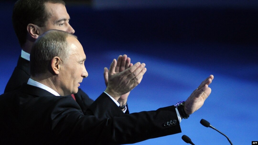 President Dmitry Medvedev (back) and Prime Minister Vladimir Putin wave to delegates at the United Russia congress on November 27.