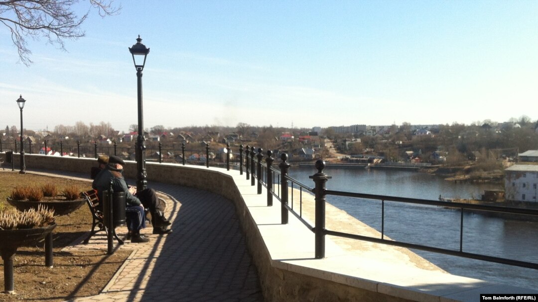 A couple looks over the river from Narva toward Russia. Are Estonia's Russians looking wistfully toward the motherland as well?